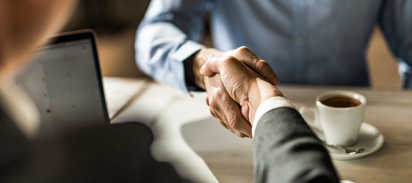 Business handshake over coffee at meeting
