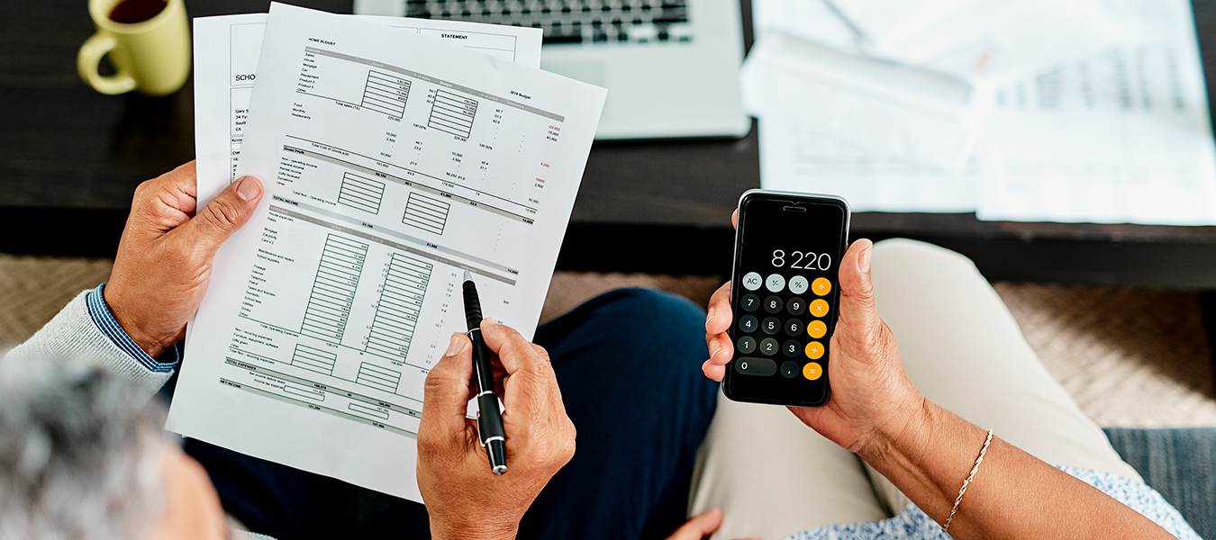 Couple reviewing financial papers with phone calculator